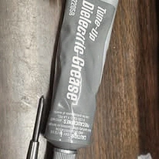 Dielectric grease and hand tools laid out for a connector repair