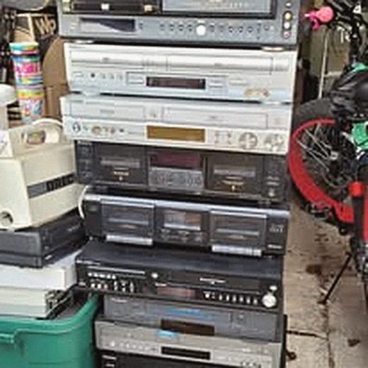 Shelf of audio and video equipment queued for service at the shop