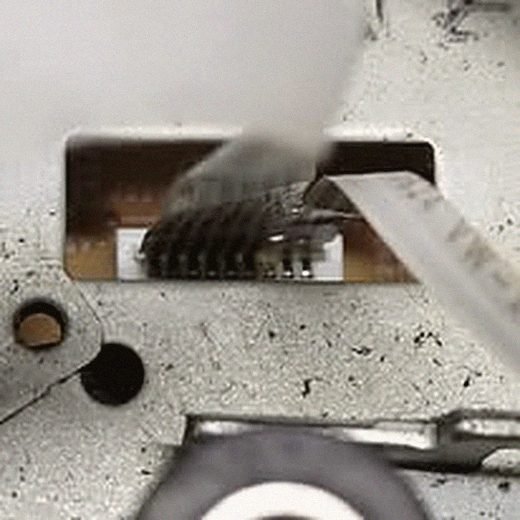 Close-up of board-level soldering work under bench light