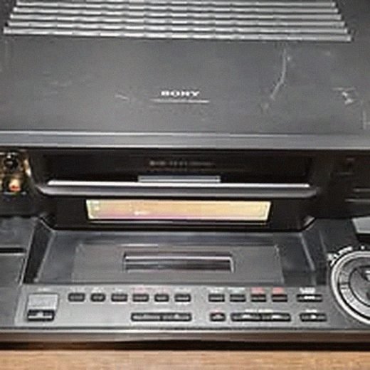 VCR unit with its tape tray open on the repair bench