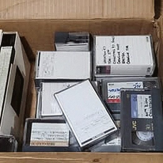Shelf of VHS tapes queued for digitizing